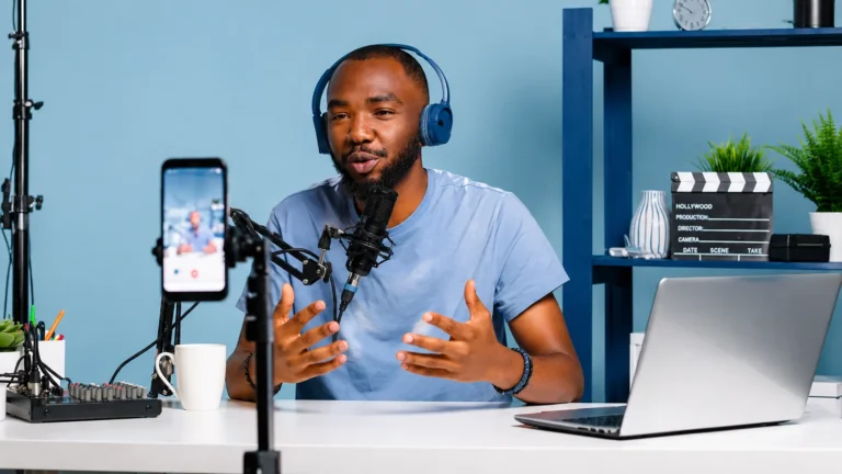 Social media engagement creator recording content in a podcast studio with camera and microphone setup